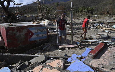 A man holds the gate of a damaged house after the passage of Hurricane Melissa in Boca de Dos Rios village, Santiago de Cuba province, Cuba on October 30, 2025. (Yamil Lage/AFP)