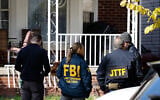 Members of the FBI Joint Terrorism Task Force stand in the front yard as they search a home in Dearborn, Michigan, on October 31, 2025. (JEFF KOWALSKY / AFP)