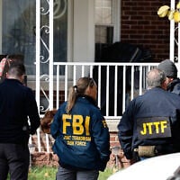Members of the FBI Joint Terrorism Task Force stand in the front yard as they search a home in Dearborn, Michigan, on October 31, 2025. (JEFF KOWALSKY / AFP)