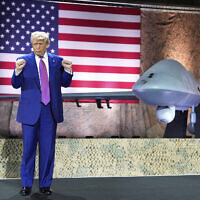 US President Donald Trump gestures backdropped by an MQ-9 Reaper drone at the Al Udeid Air Base, Thursday, May 15, 2025, in Doha, Qatar. (AP Photo/Alex Brandon)