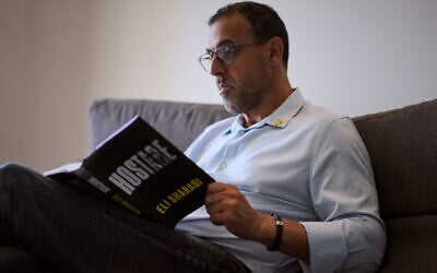 Eli Sharabi, who was abducted during the Hamas cross-border attack on Israel on October 7, 2023, and held hostage by Hamas for 16 months, poses with his new book "Hostage" for a photo in Herzliya, on September 18, 2025. (AP Photo/Ariel Schalit) Eli Sharabi, who was abducted during the Hamas cross-border attack on Israel on October 7, 2023, and held hostage by Hamas for 16 months, poses with his new book "Hostage" for a photo in Herzliya, on September 18, 2025. (AP Photo/Ariel Schalit)