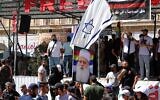 A man waves an Israeli flag over a picture of Sheikh Muafak Tarif, the spiritual leader of the Druze in Israel, during a weekly rally in Sweida, southern Syria, on September 20, 2025. (AP Photo/Fahd Kiwan)