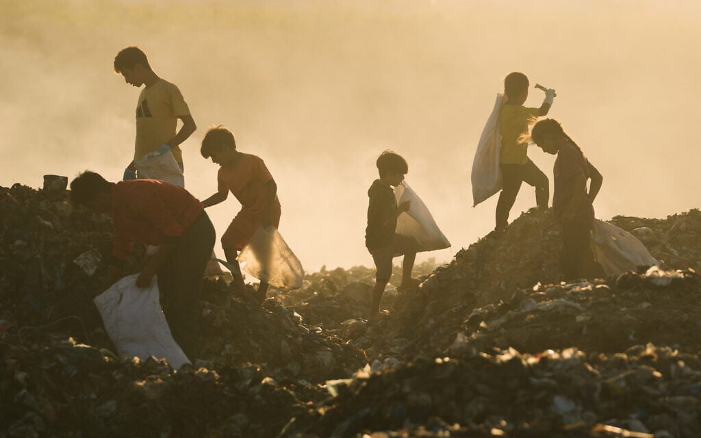 Displaced Palestinian children search for firewood and plastic in a landfill beside the makeshift tent camp where they are taking shelter in Khan Younis, southern Gaza Strip, on September 30, 2025. (AP/Jehad Alshrafi)