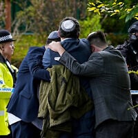 Members of the Jewish community comfort each other following a deadly terror attack during Yom Kippur services at the Heaton Park Hebrew Congregation synagogue in Crumpsall, Manchester, northern England, October 2, 2025. (Peter Byrne/PA via AP)