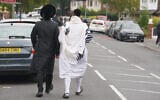 Orthodox Jewish men walk near the scene of a deadly terror attack at Heaton Park Hebrew Congregation synagogue, in Crumpsall, Manchester, England, October 2, 2025. (AP Photo/Ian Hodgson)