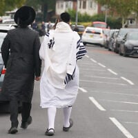 Orthodox Jewish men walk near the scene of a deadly terror attack at Heaton Park Hebrew Congregation synagogue, in Crumpsall, Manchester, England, October 2, 2025. (AP Photo/Ian Hodgson)