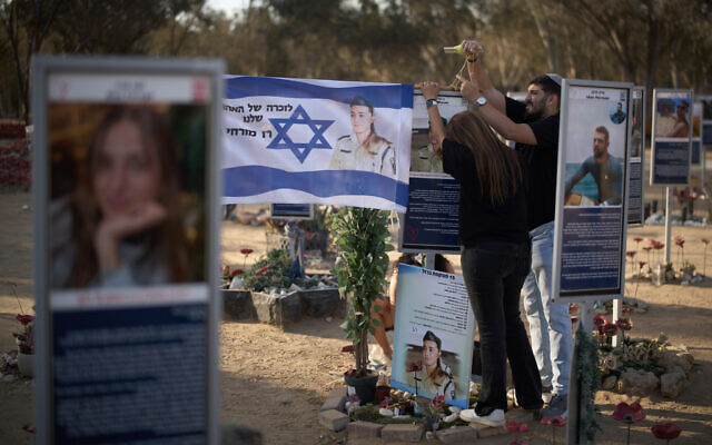 Relatives place a flag with a picture of Raz Mizrahi, who was killed in the October 7, 2023 cross-border attack by Hamas, as they visit the memorial site of Nova music festival, near the Kibbutz Reim, southern Israel, Monday, October 6, 2025. (AP/Leo Correa) Relatives place a flag with a picture of Raz Mizrahi, who was killed in the October 7, 2023 cross-border attack by Hamas, as they visit the memorial site of Nova music festival, near the Kibbutz Reim, southern Israel, Monday, October 6, 2025. (AP/Leo Correa)