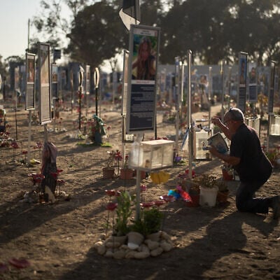 Jojo Rabia cleans a box used for lighting candles as he visits the site where his two sons were killed on Oct. 7, 2023, cross-border attack by Hamas at the Nova music festival, near the Kibbutz Reim, southern Israel, Monday, Oct. 6, 2025. (AP Photo/Leo Correa)