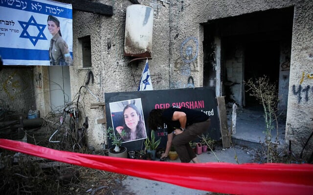 A woman places a candle at a tribute for Ofir Shoshani during a memorial marking two years since the deadly Hamas cross-border attack on Israel, in Kibbutz Kfar Aza, Oct. 7, 2025. (AP Photo/Ohad Zwigenberg)