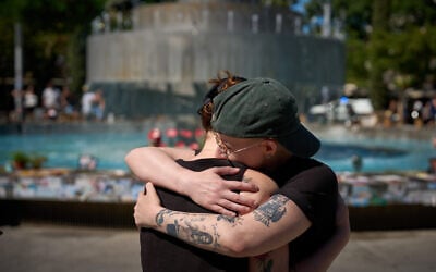People embrace at a memorial marking the second anniversary of the Hamas onslaught of October 7, 2023, at Tel Aviv's Dizengoff Square, October 7, 2025. (AP Photo/Emilio Morenatti)