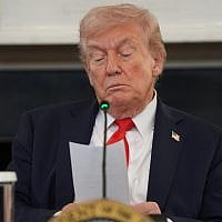 US President Donald Trump reads a note handed to him by Secretary of State Marco Rubio during a roundtable meeting on antifa in the State Dining Room at the White House, October 8, 2025, in Washington. (AP Photo/Evan Vucci)