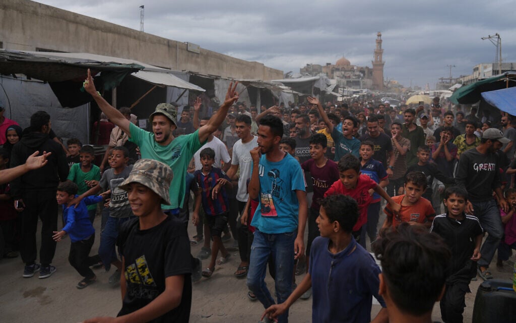 Palestinians celebrate following the announcement that Israel and Hamas have agreed to the first phase of a plan to pause the fighting that would see the release of the hostages, in Khan Younis, southern Gaza Strip, Oct. 9, 2025. (AP Photo/Jehad Alshrafi)