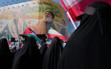 Iranian women wave Palestinian and Iranian flags in front of a banner showing the late commander of the Iranian Revolutionary Guard expeditionary Quds Force, Gen. Qassem Soleimani, left, and two late Hezbollah leaders Hassan Nasrallah, center, and Hashem Safieddine, during an anti-Israeli rally after the Friday prayers at the Enghelab-e-Eslami (Islamic Revolution) Square, in Tehran, Iran, October 10, 2025. (AP Photo/Vahid Salemi)