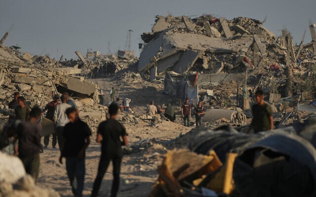 Displaced Palestinians inspect the remains of their destroyed homes in the heavily damaged Sheikh Radwan neighborhood in Gaza City, Saturday, Oct. 11, 2025. (AP/Abdel Kareem Hana)