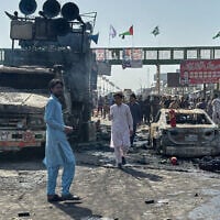 Local residents stand by burnt vehicles after police in Pakistan clashed with thousands of protesters during a march in support of Palestinians, in Muridke near Lahore, Pakistan, October 13, 2025. (AP Photo/Jahanzeb Khan)
