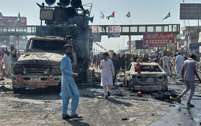 Local residents stand by burnt vehicles after police in Pakistan clashed with thousands of protesters during a march in support of Palestinians, in Muridke near Lahore, Pakistan, October 13, 2025. (AP Photo/Jahanzeb Khan)