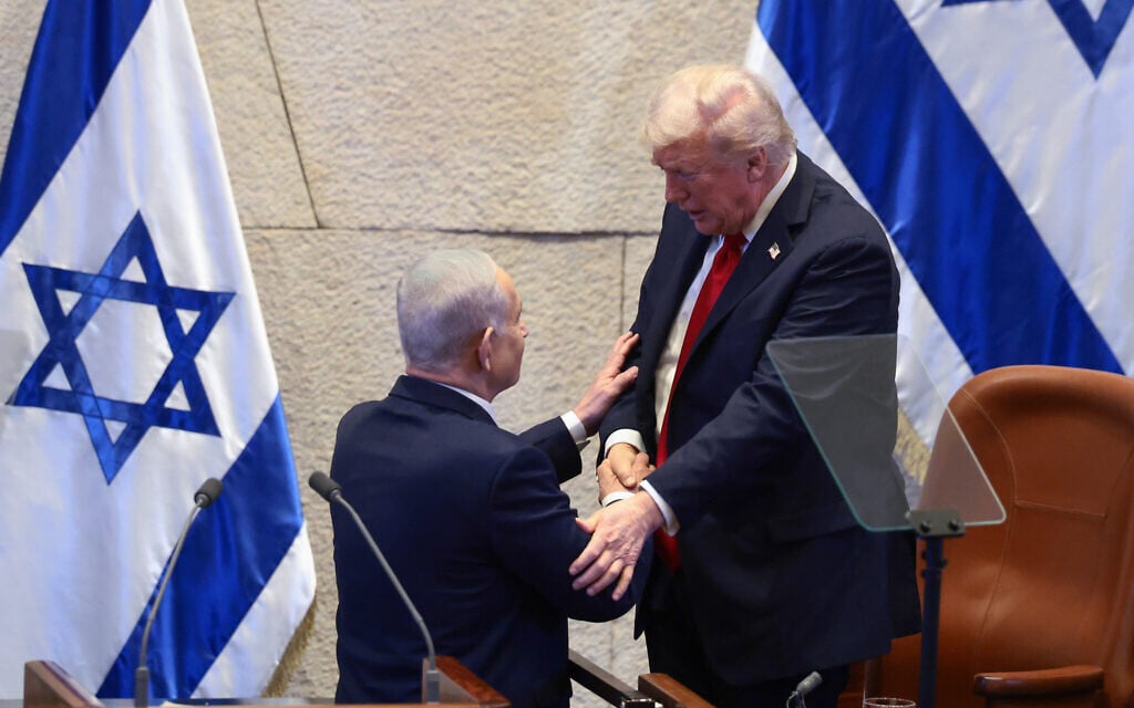 US President Donald Trump talks with Prime Minister Benjamin Netanyahu at the Knesset, Oct. 13, 2025. (Evelyn Hockstein/Pool via AP)