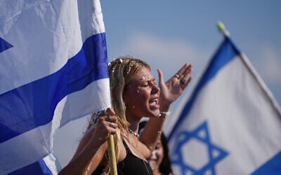 People hold Israeli flags in celebration after the arrival of freed hostages at Beilinson Hospital in Petah Tikva, Israel, following their release from Hamas captivity in the Gaza Strip, October 13, 2025. (AP Photo/Ariel Schalit)