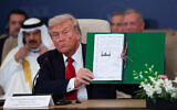 US President Donald Trump poses with a signed agreement at a world leaders' summit on ending the Gaza war, in Sharm el Sheikh, Egypt, October 13, 2025. (Suzanne Plunkett, Pool Photo via AP)