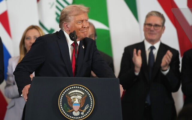 US President Donald Trump stands at the podium during a summit on peace in Gaza, amid applause from leaders including Britain's Prime Minister Keir Starmer, right, in the Egyptian resort town of Sharm El-Sheikh, October 13, 2025. (AP Photo/Amr Nabil)
