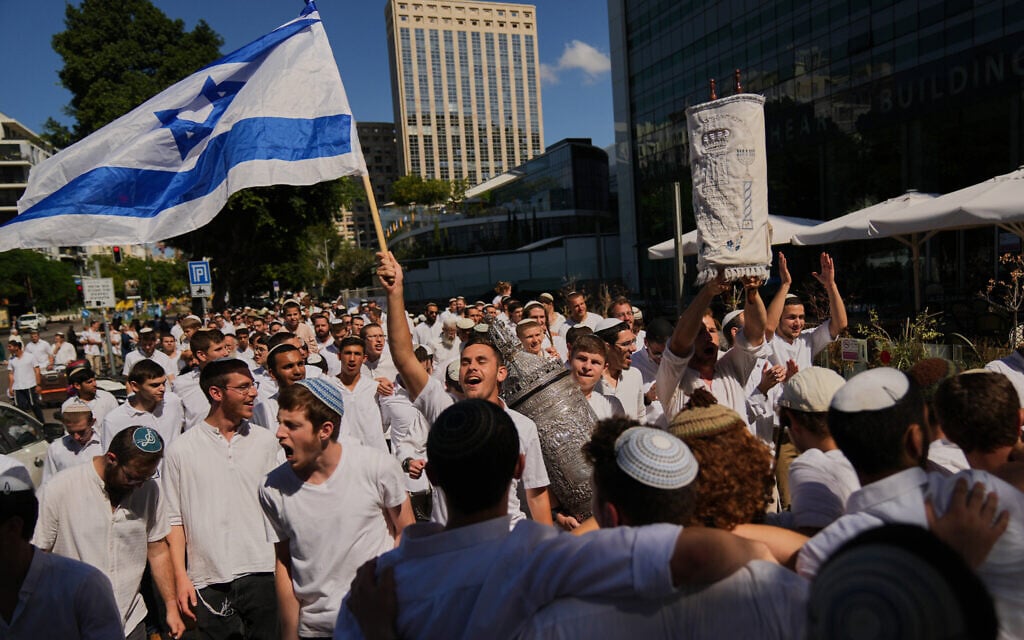 Jewish revelers dance and hold up a Torah scroll as they celebrate the holiday of Simchat Torah, in Tel Aviv, Oct. 14, 2025. (AP Photo/Francisco Seco)