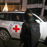 Illustrative: A gunman wearing the uniform of the al-Qassam Brigades, the military wing of Hamas, stands guard as Red Cross vehicles transporting hostages' remains leave for Israel, in Gaza City, Tuesday, October 14, 2025. (AP Photo/Yousef Al Zanoun)