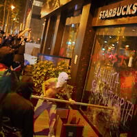Rioters break the shop window of a Starbucks amid anti-Israel demonstrations in Barcelona on October 15, 2025. (AP Photo/Joan Mateu Parra)