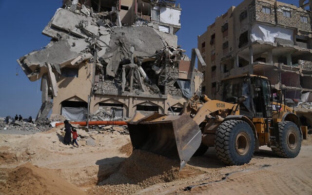 Members of the Hamas terror group apparently work on searching for bodies of the hostages in an area in Hamad City, Khan Younis, in the southern Gaza Strip, Oct. 17, 2025. (AP Photo/Abdel Kareem Hana)