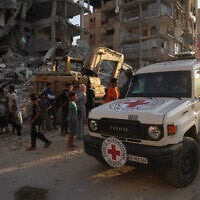 A Red Cross vehicle arrives at the site where Hamas operatives work on searching for bodies of the hostages in an area in Hamad City, Khan Younis, in the southern Gaza Strip, October 17, 2025. (AP Photo/Abdel Kareem Hana)