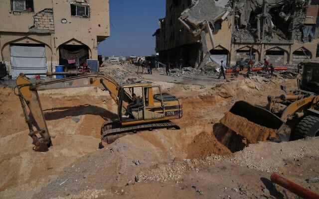 Illustrative: Members of the Hamas terrorist group search for bodies of the slain hostages in an area in Hamad City, Khan Younis, in the southern Gaza Strip, October 17, 2025. (AP Photo/Abdel Kareem Hana)