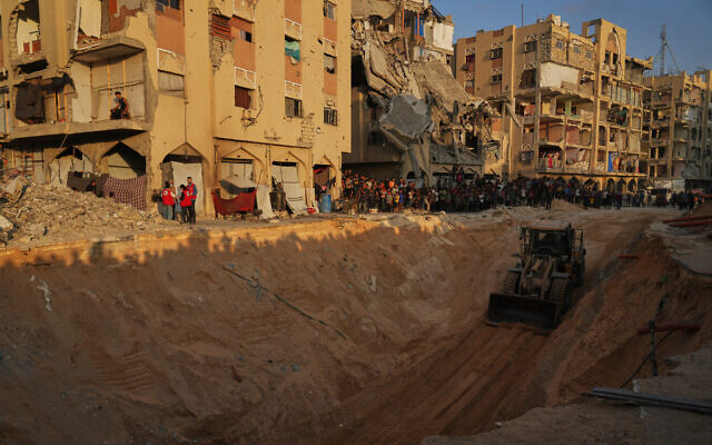 Palestinians watch members of the Hamas militant group searching for bodies of the hostages in an area in Hamad City, Khan Younis, in the southern Gaza Strip, Friday, Oct. 17, 2025. (AP Photo/Abdel Kareem Hana)