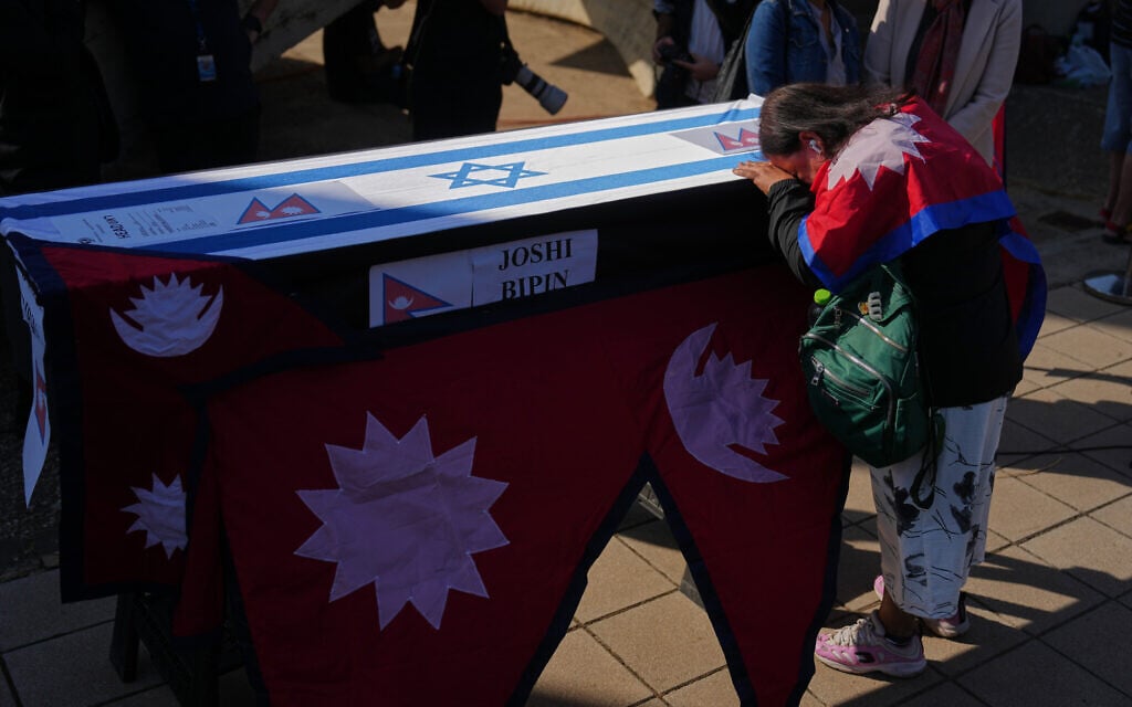 Relatives and friends of Nepali national Bipin Joshi, who was taken hostage by Hamas into Gaza, stand next to his coffin during a farewell ceremony before his body is flown to Nepal for burial, at Ben Gurion Airport, Oct. 19, 2025. (AP/Ariel Schalit)
