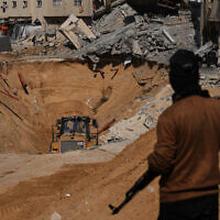 Members of the Hamas terrorist group search underground for the bodies of Israeli hostages amid destroyed buildings in Khan Younis, in the southern Gaza Strip, October 19, 2025. (AP Photo/Abdel Kareem Hana)