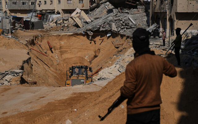Members of the Hamas terrorist group search underground for the bodies of Israeli hostages amid destroyed buildings in Khan Younis, in the southern Gaza Strip, October 19, 2025. (AP Photo/Abdel Kareem Hana)