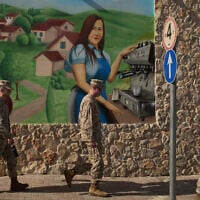 US Marine soldiers walk past a mural of a coffee shop near Kibbutz Kfar Aza, southern Israel, Tuesday, Oct. 21, 2025. (AP Photo/Leo Correa)