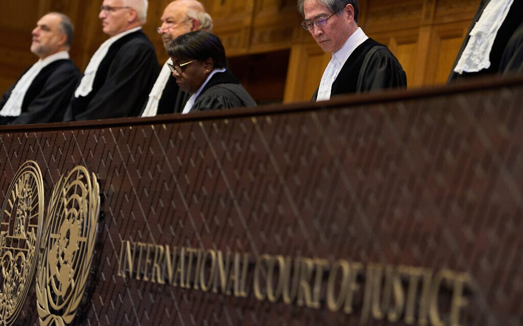 Presiding Judge Yuji Iwasawa, right, starts reading the advisory opinion of the International Court of Justice on what Israel must do to ensure humanitarian aid reaches Palestinians in Gaza and the West Bank, in The Hague, Netherlands, Wednesday, Oct. 22, 2025. (AP Photo/Peter Dejong)