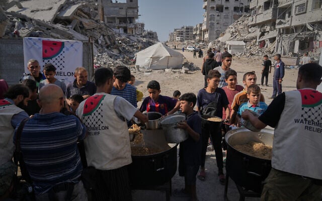Palestinians receive donated food at a community kitchen in Gaza City, October 23, 2025. (AP/Abdel Kareem Hana) Palestinians receive donated food at a community kitchen in Gaza City, October 23, 2025. (AP/Abdel Kareem Hana)