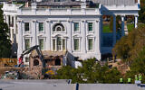 Construction workers, bottom right, atop the US Treasury, watch as work continues on a largely demolished part of the East Wing of the White House, October 23, 2025, in Washington, before construction of a new ballroom. (AP Photo/Jacquelyn Martin)