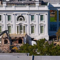 Construction workers, bottom right, atop the US Treasury, watch as work continues on a largely demolished part of the East Wing of the White House, October 23, 2025, in Washington, before construction of a new ballroom. (AP Photo/Jacquelyn Martin)