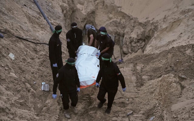 Hamas terrorists carry a white bag believed to contain a body, retrieved from a tunnel during a search for the remains of hostages in Hamad City, Khan Younis, southern Gaza, October 28, 2025. (AP Photo/Jehad Alshrafi) Hamas terrorists carry a white bag believed to contain a body, retrieved from a tunnel during a search for the remains of hostages in Hamad City, Khan Younis, southern Gaza, October 28, 2025. (AP Photo/Jehad Alshrafi)