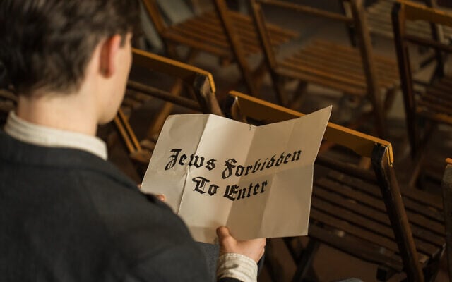 Ewan Horrocks as Helmuth Hubener holds a sign in a still from 'Truth and Treason.' (Courtesy Angel Studios)