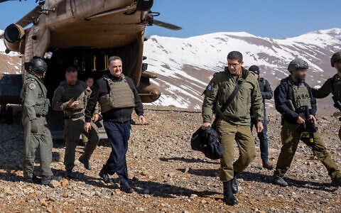 Defense Minister Israel Katz (left) and his military secretary, Brig. Gen. Guy Markizeno get off an Israeli Air Force helicopter in the Mount Hermon area in southern Syria, March 11, 2025. (Emanuel Fabian/Times of Israel)
