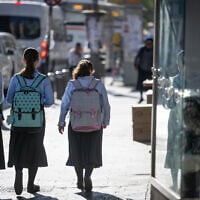 Ultra-Orthodox girls walk to school in the neighborhood of Mea Shearim, Jerusalem, on August 30, 2023. (Chaim Goldberg/Flash90)