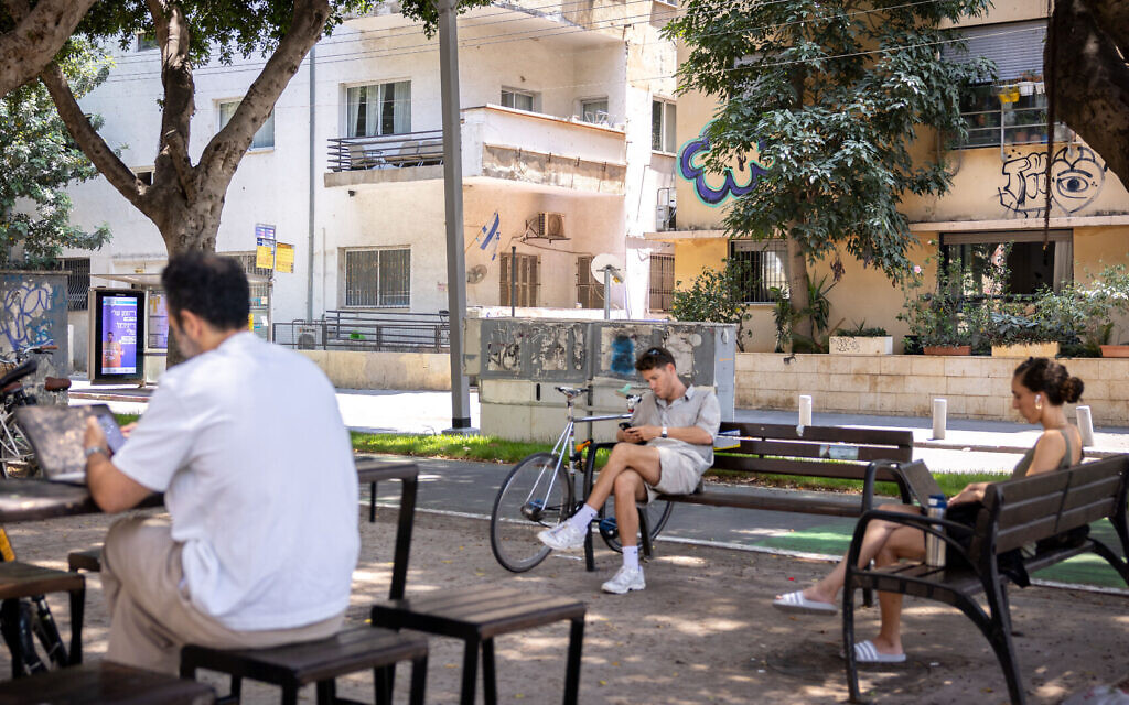 Illustrative: People look at electronic devices while relaxing in Tel Aviv on June 4, 2025. (Miriam Alster/FLASH90) Illustrative: People look at electronic devices while relaxing in Tel Aviv on June 4, 2025. (Miriam Alster/FLASH90)