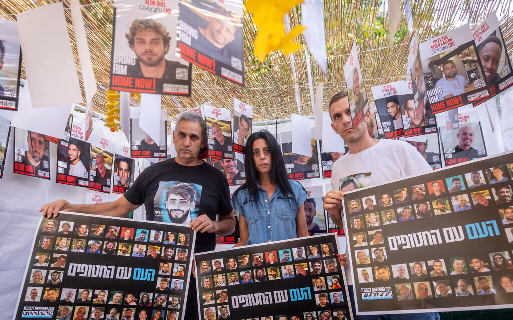 Families of Israelis held hostage by Hamas in Gaza, in a sukkah outside the PM's residence in Jerusalem, with photographs of the hostages, on October 5, 2025. (Chaim Goldberg/FLASH90)