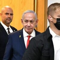 Prime Minister Benjamin Netanyahu (C) arrives at the District Court in Tel Aviv, to testify in the ongoing criminal trial against him, on October 15, 2025. (Reuven Kastro/ POOL)