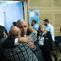 Committee chair Yesh Atid MK Mickey Levy embraces a bereaved family member at a State Control Committee meeting at the Knesset on October 22, 2025 (Chaim Goldberg/Flash90)