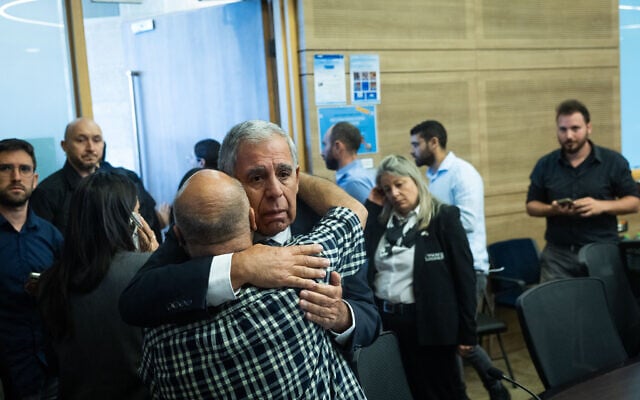 Committee chair Yesh Atid MK Mickey Levy embraces a bereaved family member at a State Control Committee meeting at the Knesset on October 22, 2025 (Chaim Goldberg/Flash90)