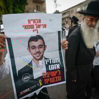 A demonstrator holds up a poster of Haredi draft evader Ariel Shamai which reads: "Bring him back to yeshiva now!" and in smaller print on the left: "Until the last hostage," imitating the rhetoric of the hostage families' protest movement, during an anti-draft demonstration in Jerusalem on October 22, 2025. (Yonatan Sindel/Flash90)