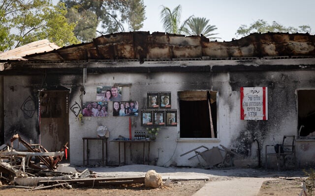 Pictures of victims hang on the outer wall of a Kibbutz Nir Oz home gutted in the Hamas onslaught of October 7, 2023, as seen in the Gaza border community on October 23, 2025. (Chaim Goldberg/Flash90)